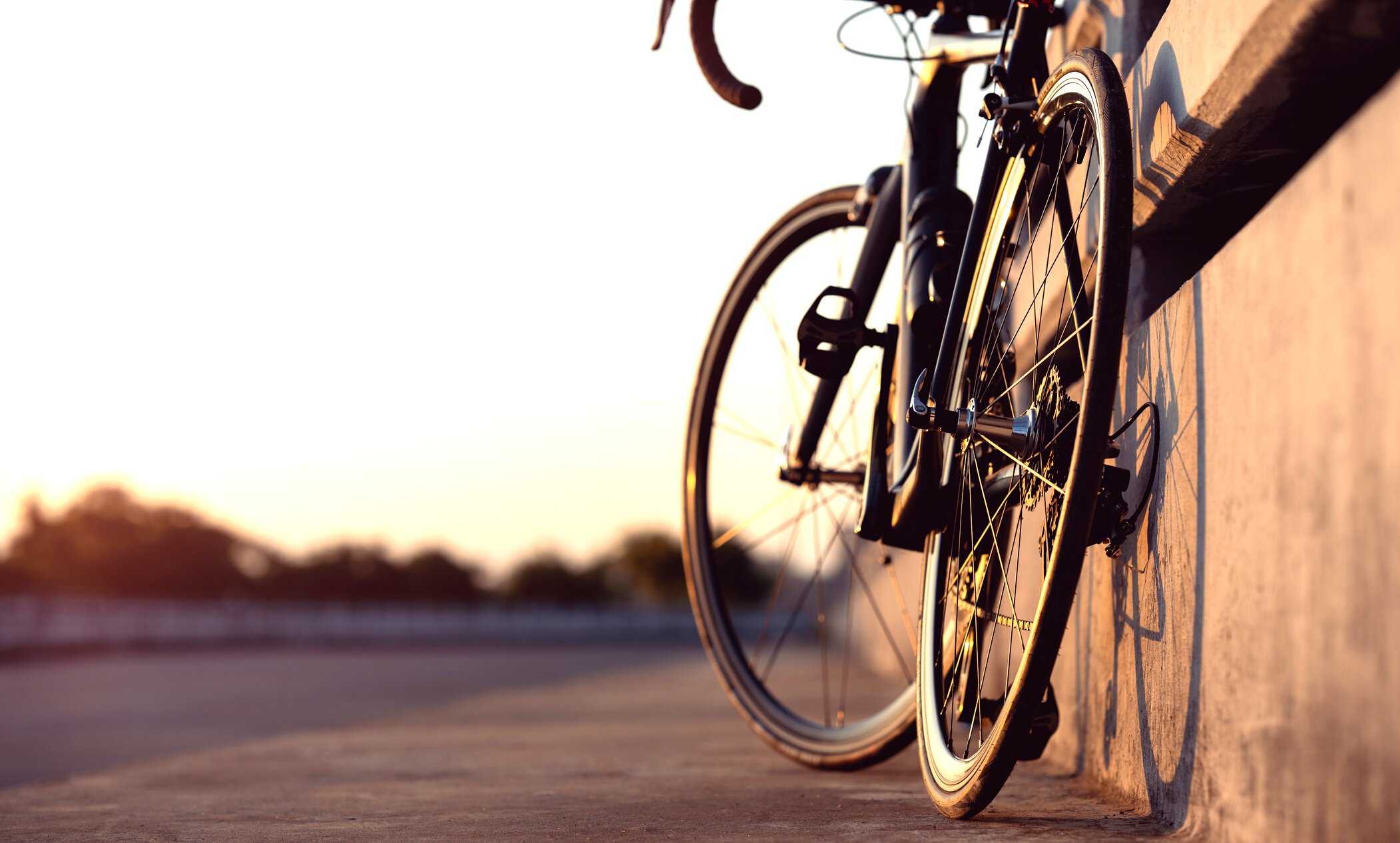 Road bike parked on a beautiful road sunset, on the bridge warm light with copy space.